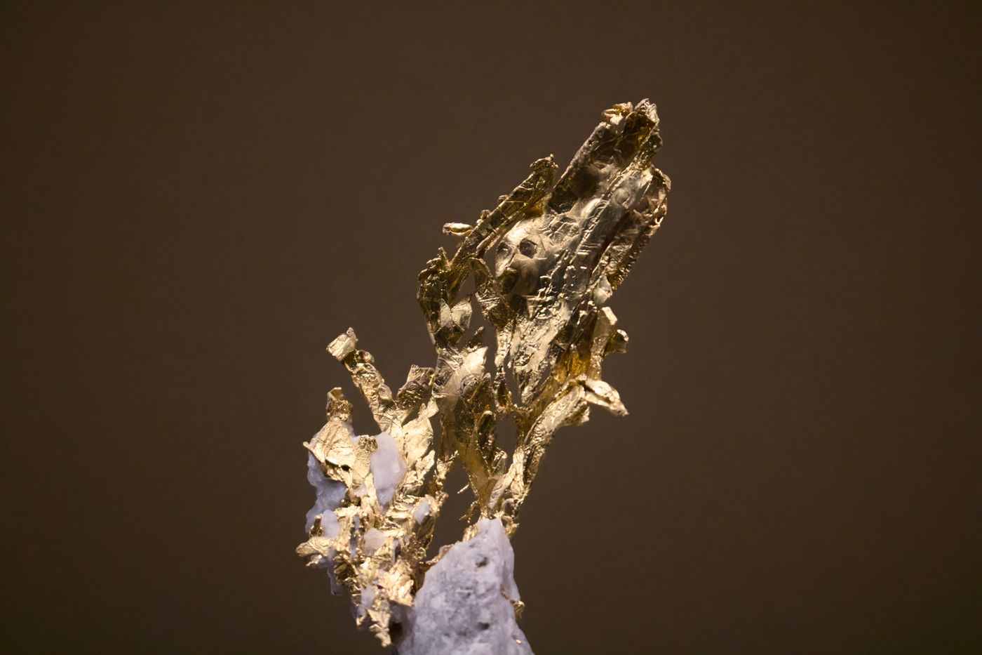Natural raw gold nugget specimen on dark surface